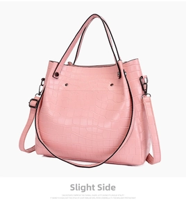 Side view of pink tote bag with crocodile texture, reinforced rivets and metal hardware