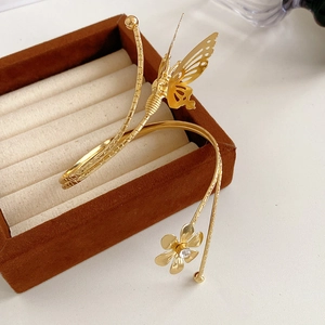Close-up of golden butterfly and flower cuff bracelet with rhinestones on jewelry box