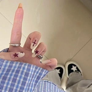 Press-on nails featuring gradient beige base with gothic black cross and purple stars