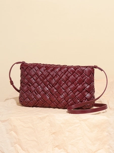Woven burgundy faux leather shoulder bag with a pleated design and slim adjustable strap