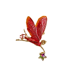Vintage enamel fairy brooch with gradient wings and star pendant on a white background
