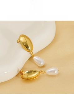 Macro shot of 18K gold plated irregular earrings with elegant white teardrop pearls