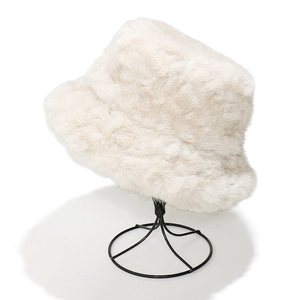 Detailed view of the soft faux fur texture on a cream winter bucket hat on display