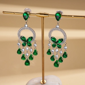 Detailed view of silver butterfly earrings with green stones and elegant crystal tassels