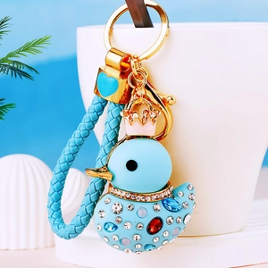 Sparkling duck keychain with blue woven strap and gold crown decoration on cup