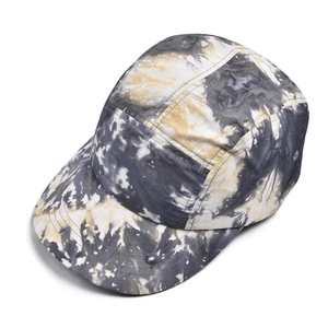 Détail d'une casquette camper 5 pans avec imprimé tie-dye jaune et noir et œillets d'aération