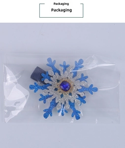 Close-up of winter snowflake hair clip with blue rhinestones and silver glitter finish