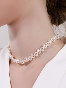 Detail shot of white multi-layer braided faux pearl choker on a fashion model neckline