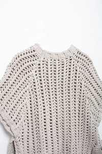 Detail of the chunky knit pattern and cutout neckline on this beige casual sweater
