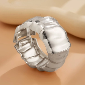 Macro detail of silver-colored irregular wavy metal cuff bracelet with s925 hallmark