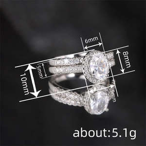 Silbernes Doppelring-Set mit ovalem Diamanten und Pavé auf schwarzem Hintergrund