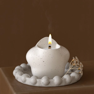 Star-shaped ceramic candle holder with pearl edge tray on brown leather background