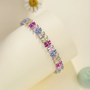 Detail of colorful rectangular zircon stones set on a silver bracelet over a beige base