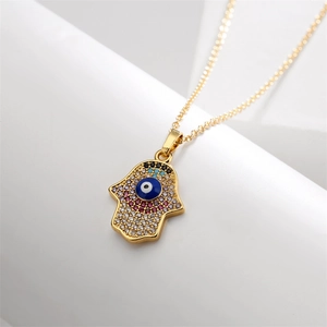 Vue détaillée du collier main de Fatma dorée avec zircons et motif œil protecteur