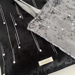Detail of velvet tote bags featuring vertical silver lines and faux pearl decorations