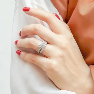 Detailed view of pear-cut zircon sterling silver rings on model hand with wavy band