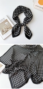 Detail of a square silk scarf with geometric G-letter print and elegant white borders