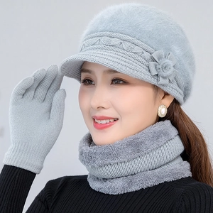 Close-up of gray knit winter hat with floral detail, matching neck warmer and gloves set