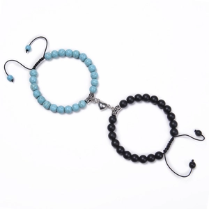 Close-up of sky blue and black beaded couple bracelets with heart-shaped magnetic clasp