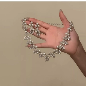 Elegant vintage pearl and diamond flower jewelry set featuring a necklace and earrings