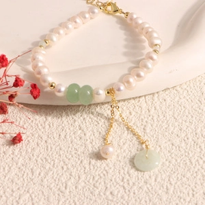 Close-up of elegant freshwater pearl bracelet with green beads and 14K gold lobster clasp