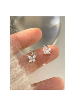 Close-up of double butterfly stud earrings featuring white cubic zirconia in silver