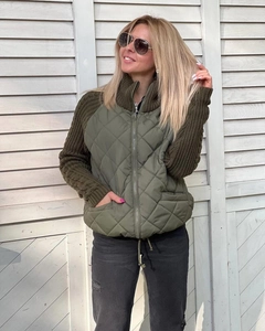 Detail of army green quilted jacket with knit sleeves and functional side pockets