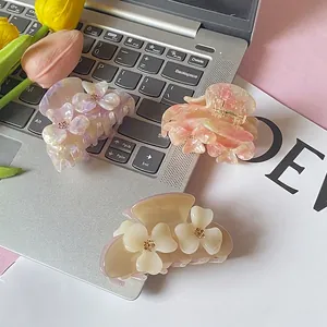 Three elegant flower hair claws in purple, pink, and white with a glossy acetate finish