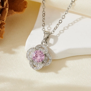 Détail macro du pendentif fleur en argent avec pierre rose et sertissage de zircons