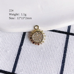 Macro shot of 1.1g golden sun pendant with white rhinestones and size parameters