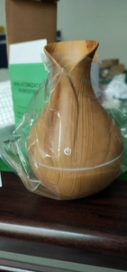 Detail view of mini wood grain flower vase humidifier inside protective plastic wrap