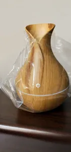 Detail view of mini wood grain flower vase humidifier inside protective plastic wrap