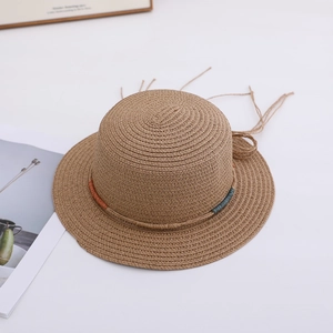 Detail of hand-woven brown straw hat with colorful braided rope and flat top design