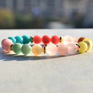 Macro shot of 8mm natural stone beads bracelet with colorful gems and golden spacers