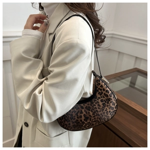 Side view of trendy leopard print crescent bag styled with a beige blazer suit