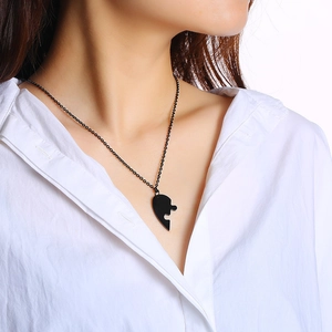 Heart-shaped puzzle pendant necklace in black finish worn by a model on white background