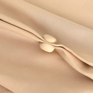 Beige magnetic hijab clip secures pleated light brown fabric with stylish minimal design