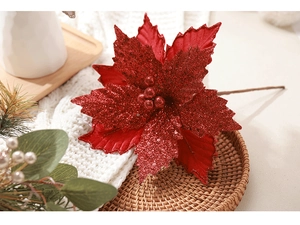 Close-up of red velvet Christmas poinsettia with glitter petals on a woven tray