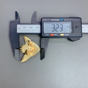 Digital caliper measuring the width of a gold plated red heart wing ring, size 32.3mm