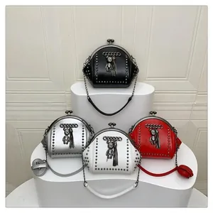 Detail of studded shell-shaped bags in four colors with crystal bear charms and tassels
