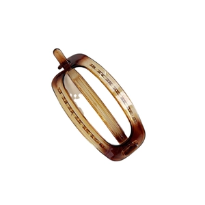 Minimalist oval amber resin hair clip with tortoiseshell pattern on white background
