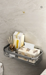 Detail of grey wall-mounted bathroom shelf organizer with adhesive hooks and accessories