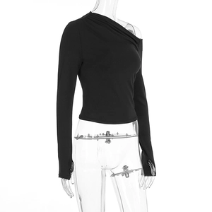 Detail of black off-shoulder top featuring ruched shoulder design and functional thumbholes