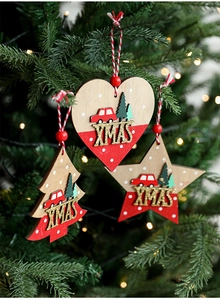 Close-up of wooden Xmas ornaments with 3D car and tree motifs on a festive tree