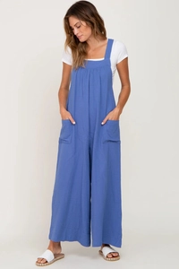 Detail of loose-fit beige maternity overalls with side pockets and cotton linen texture
