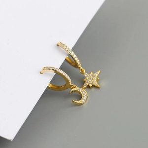 Close-up of asymmetric star and moon hoop earrings with pavé sparkling cubic zirconia