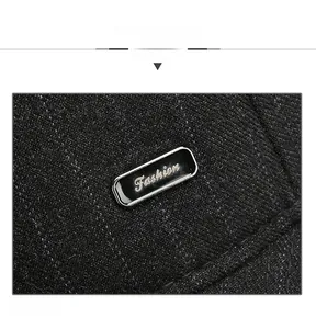 Detail view of black wool fabric texture with a gold Fashion metal emblem on the cap
