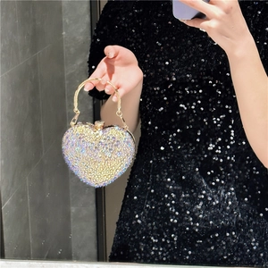 Close-up of heart-shaped evening bag with silver rhinestones and gold handle details