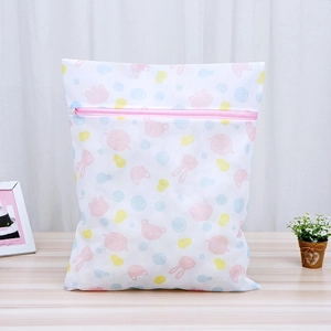 Fine mesh laundry bag with cartoon prints and pink zipper on a wooden table