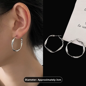 Silver geometric twisted hoop earrings for women, 3cm diameter shown on model and flat lay